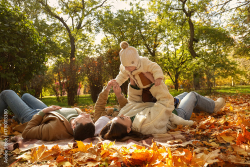 Happy family lying on plaid...