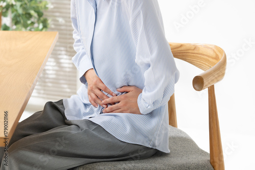 お腹を押さえる女性