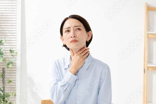 喉に違和感を感じる女性