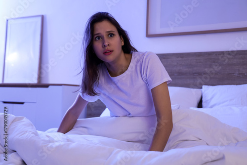 Scared young woman in bedro...