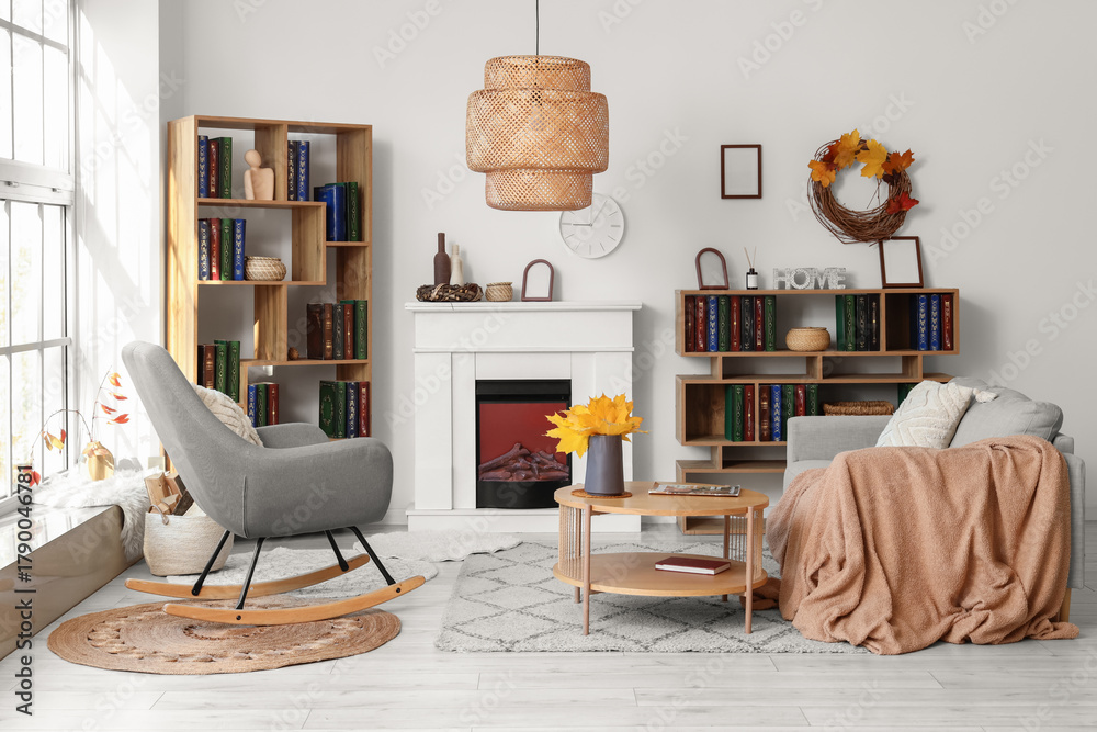 Fototapeta premium Interior of living room with autumn leaves, sofa and bookshelves
