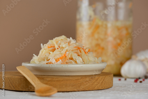 Fresh sauerkraut, pickled cabbage with carrot on a wooden board.