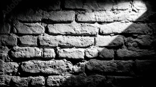 A monochrome close-up capturing rough, aged brickwork with a spotlight illuminating a square
