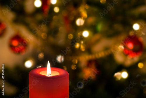 Kerze mit Weihnachtsbaum im Hintergrund
