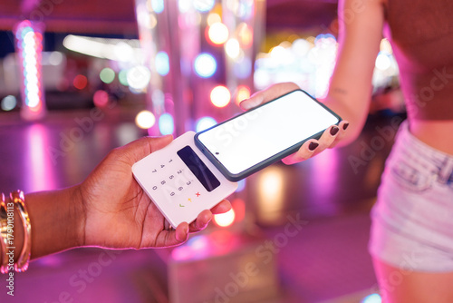 Person paying with contactless mobile phone to another person at an amusement park