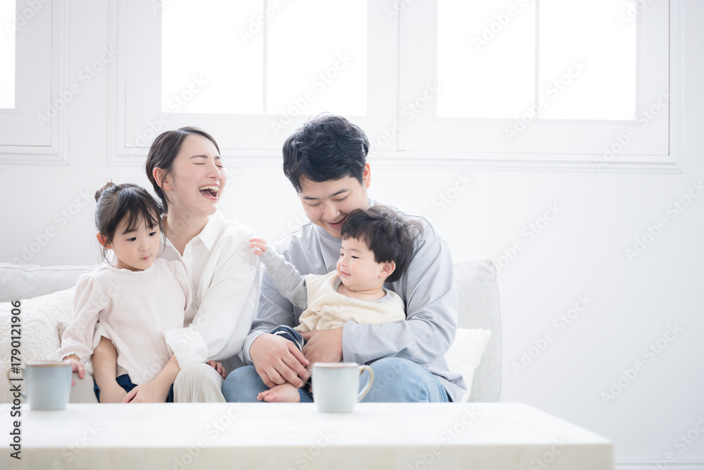 Fototapeta premium 笑いが絶えない幸せな仲良し家族の子育て・育児の日常 リビングでの子供のお世話