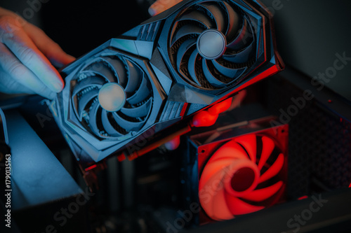 GPU installation details, Detailed scene of technician working on computer hardware components, Precise assembly of graphics card inside gaming desktop with attention to detail