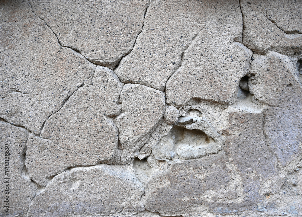 Obraz premium Cracked concrete wall showing wear and age at a construction site during the day