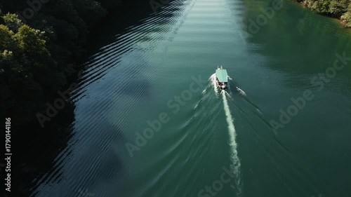Aerial view of a boat slowly sailing on a wide river in Matka Canyon, 4k