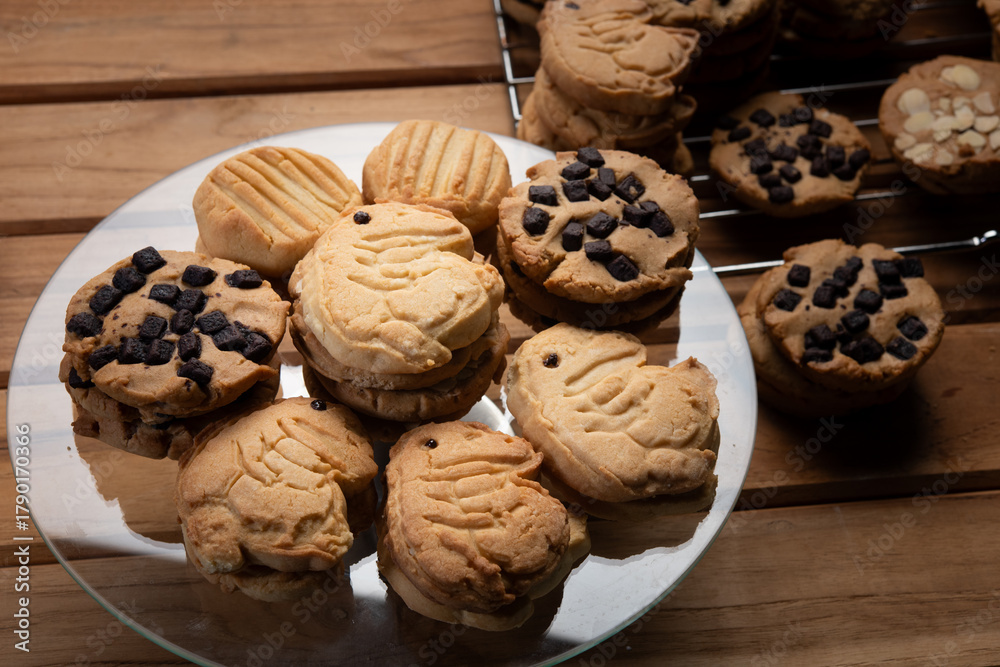 Fototapeta premium Buttery cookie with chocolate chips dessert on rustic table, fresh batch of shortbread stack cool on rack, sweet crumbly texture invite snack time joy, homemade bakery vibe with soft light warmth