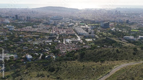 Barcelona cityscape showcasing the diverse urban landscape from an elevated perspective, featuring residential neighborhoods, sports facilities, and the sea under a clear sky