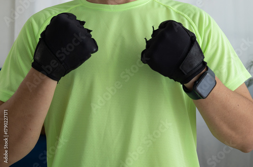 Close up of an unrecognizable man wearing sports gloves clenching his fists. Concept of strength, energy, motivation, and readiness for training