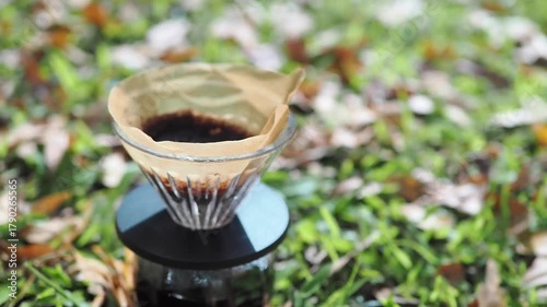 Drip coffee on the autumn morning grass