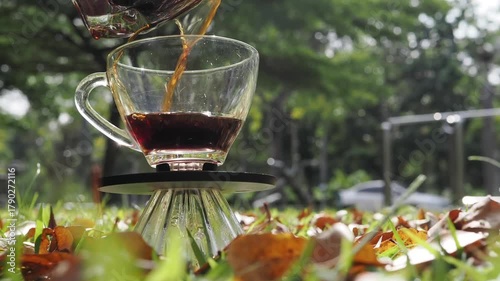 Drip coffee on the autumn morning grass