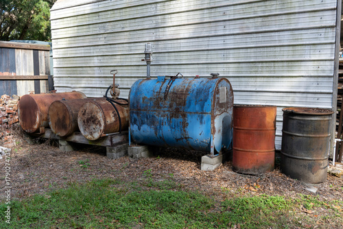 Fuel barrels and tanks alongside a building