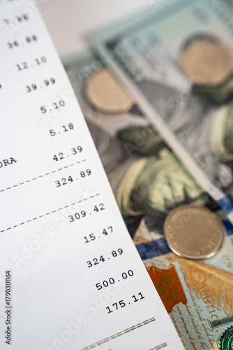US dollars and financial receipt close-up, representing accounting, income tracking, and economic analysis. 