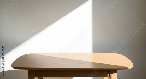 Simple wooden table against white wall in bright sunlight indoor minimalistic design