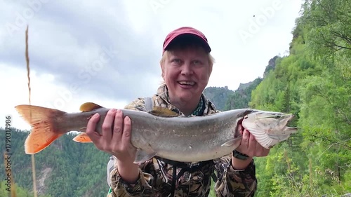 Proud female angler holds a massive fish in the wild mountain forest — triumphant smile, vibrant fins, and rugged nature create powerful imagery for adventure or fishing content.