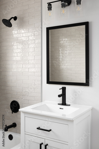 A bathroom detail with a white cabinet and sink with a black faucet and shower with brown subway tiles.