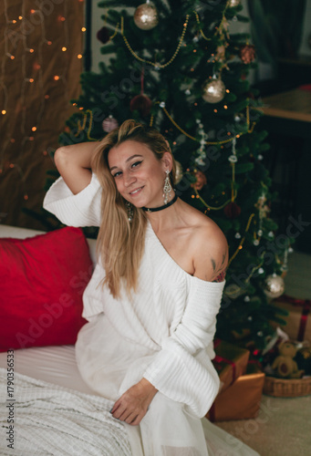 a woman in white near a Christmas tree
