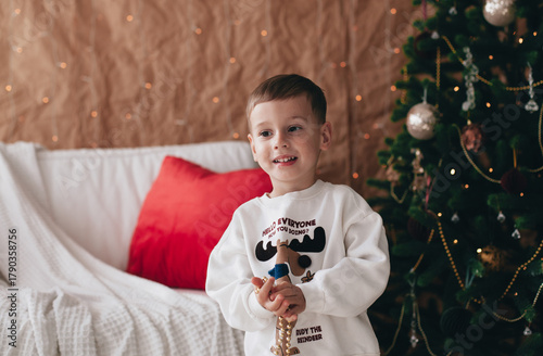 a little boy playing near a Christmas tree