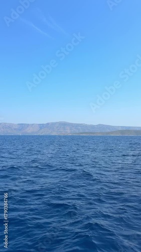 View of the Adriatic Sea and the horizon from the bow of a sailing yacht in Croatia. Peaceful travel moment under full sails, capturing freedom, adventure and maritime lifestyle.