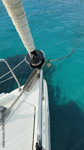 Automatic anchor chain retrieval on a yacht using a remote control during anchoring. Close-up of windlass system in action, detail from modern sailing life and nautical routine