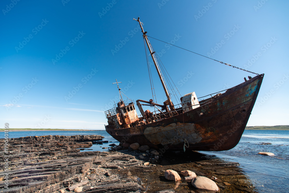 Fototapeta premium old wrecked sunken ship on the rocky shore of the Arctic Ocean