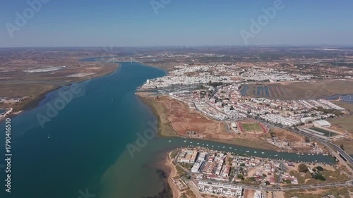 Ayamonte aerial view guadiana river and ayamonte wide river channel cutting through marshy banks urban cluster and sparkling salt pans boat trails highlight active estuarine corridor