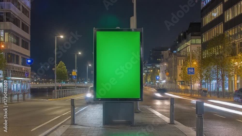 Green screen advertising billboard mockup on a busy city street at night with blurred car lights timelapse.