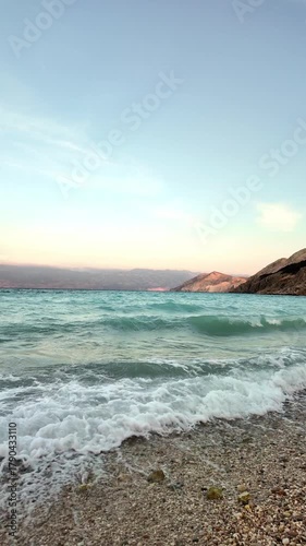 Beautiful waves on a pebble beach at sunset. Baška, Krk Island, Croatia