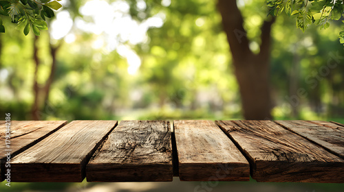 Fototapeta Naklejka Na Ścianę i Meble -  Rustic wooden planks with blurred green foliage and sunlight table weathered