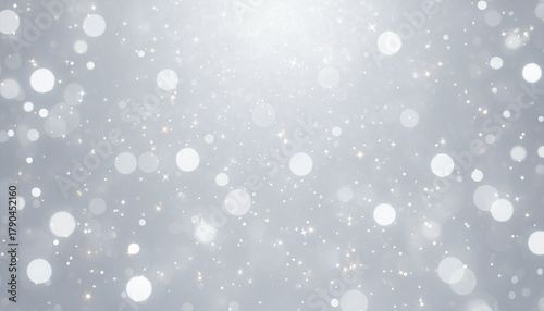 Soft white bokeh lights with sparkling silver glitter create dreamy glowing festive background