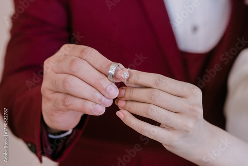 The bride and groom put the rings on their index fingers and clasped their hands together.