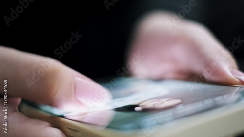 Extreme close-up macro shot of a thumb rapidly scrolling through a social media feed on a smartphone. The finger swipes quickly across the illuminated touch screen showing fast content consumption.