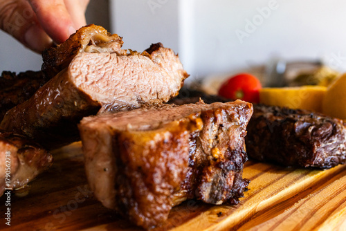 Wall Mural Delicious grilled meat on a wooden chopping board, a tasty protein-rich barbecu