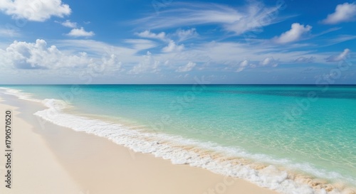 Fototapeta Naklejka Na Ścianę i Meble -  Waves gently lap the shore of a tropical beach on a sunny day