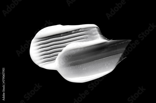 A sample of white body cosmetics on a black background