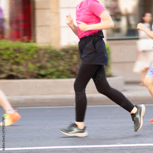 female athlete jogs along a summer street in the city