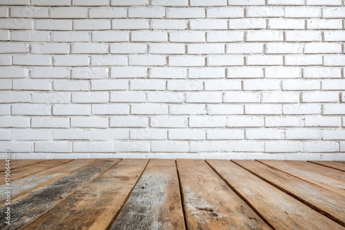 White brick wall above aged lightbrown wood planks