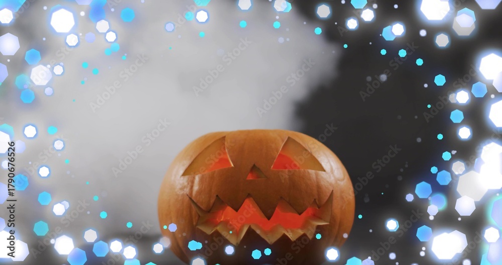 Naklejka premium Glowing carved pumpkin jack-o'-lantern casting warm studio light, with fog and hexagonal blue bokeh
