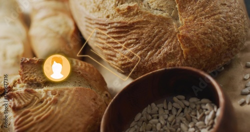 Showing crusty artisan loaf on counter, with sliced baguette, bowl of sunflower seeds, UI overlay