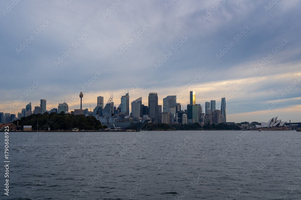 Obraz premium Sydney skyline at sunset with golden reflections on the water