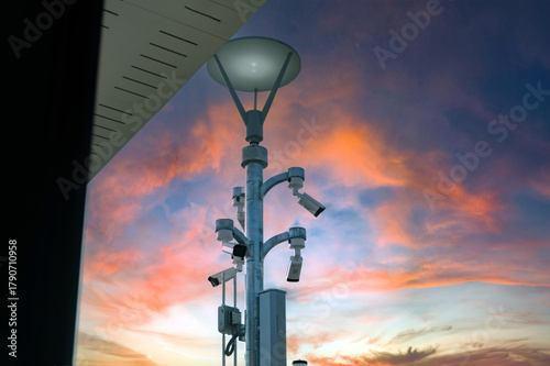 Fotografie Pixed ip cctv cameras installed on outdoor high metal post of the buildings to do security by monitoring on mobile phone and computer to save human life and property by cctv cameras instead of human