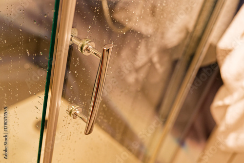 Clear shower door with fresh water droplets after use