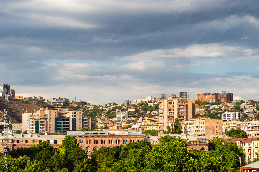 Fototapeta premium cloudy sky over sunlit district in Yerevan city