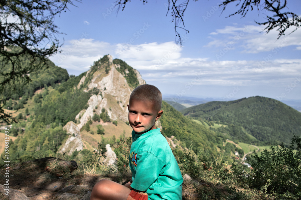 Naklejka premium Boy sitting on a mountain top with beautiful view. Vršatec, Slovakia
