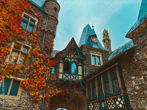 A medieval castle on a mountainside in the town of Cochem against a blue sky in autumn