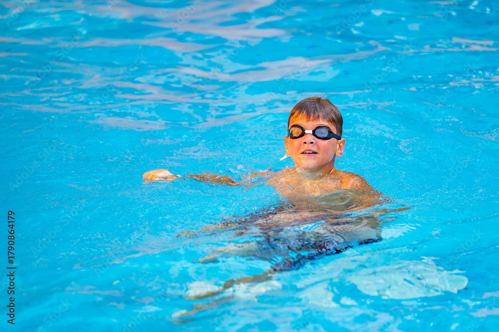 Naklejka premium happy boy swimming in the pool