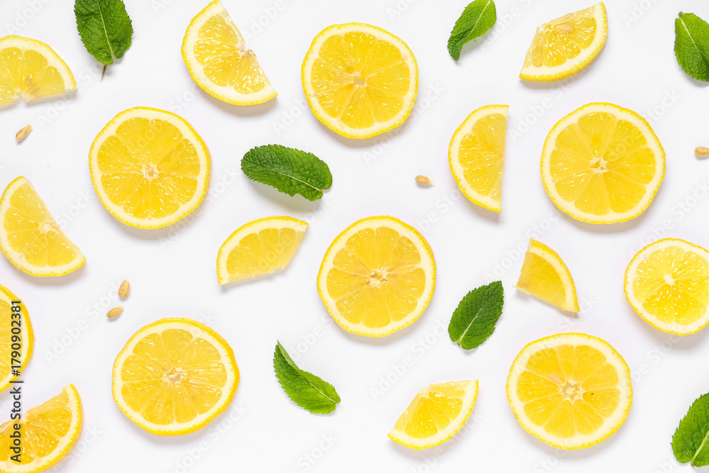 Fototapeta premium Slices of fresh ripe lemon with seeds and leaves on grey background